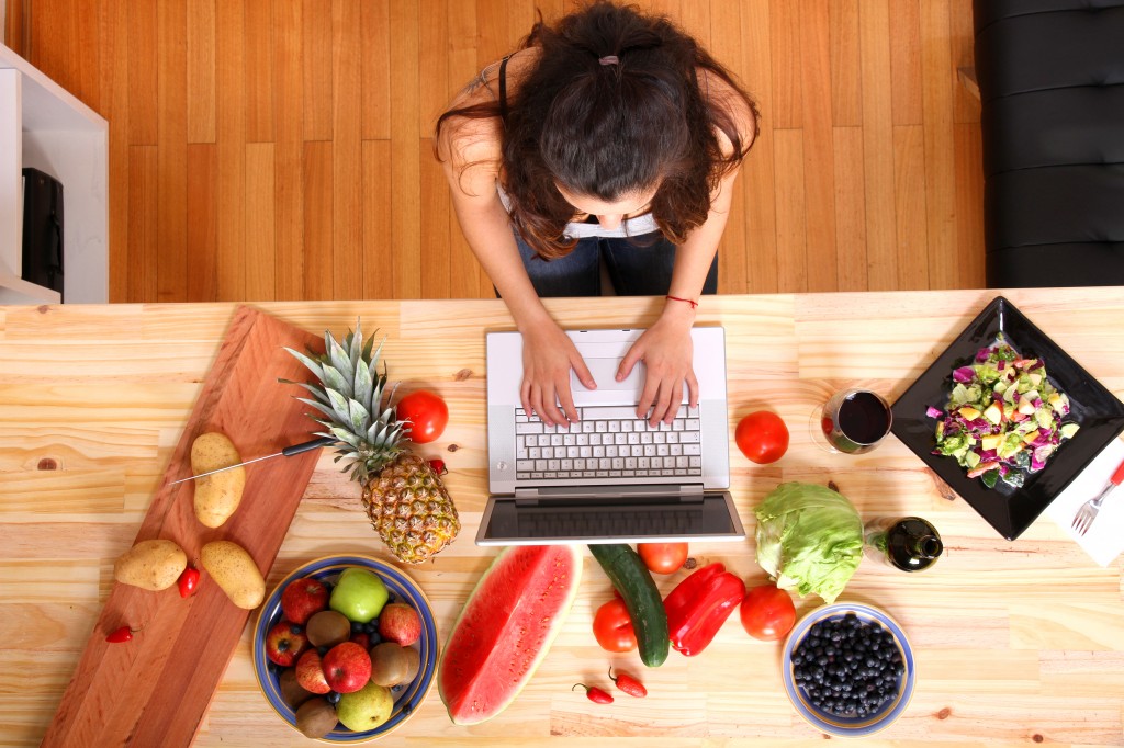 Woman using a Laptop while cooking