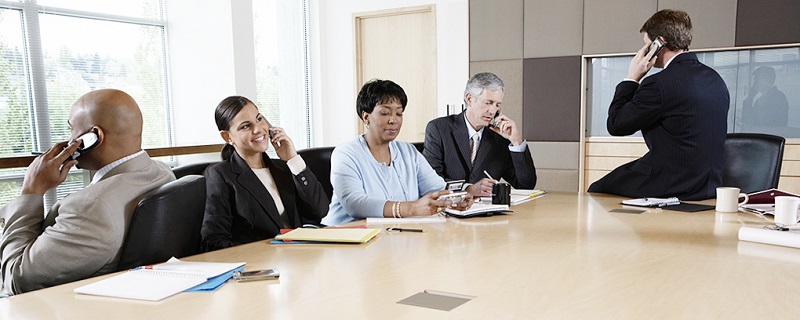 Five executives using cell phones in boardroom