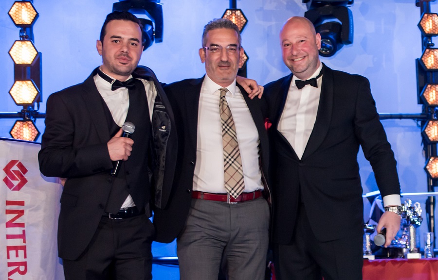 Οι κύριοι Ι. Γκαβογιάννης, Ι. Βασαλάκης και Κ. Φλόκας με φόντο banner Της Interamerican